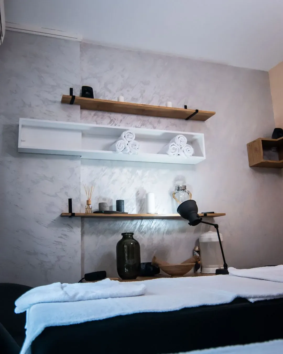 Massage room interior in Vračar — shelves, towels and the massage bed